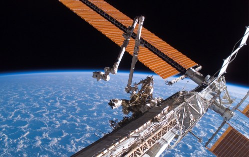 The Canadarm2 (center) and solar array panel wings on the International Space Station