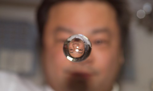 Astronaut Leroy Chiao, Expedition 10 commander and NASA ISS science officer, watches a water bubble float between him and the camera, showing his image refracted, on the IISS on January 15th, 2005