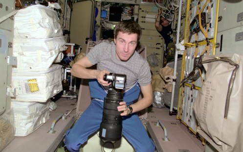 Cosmonaut Sergei K. Krikalev, Expedition One flight engineer, prepares to photograph some geographic targets of opportunity through a viewing port on the International Space Station's Zvezda (December of 2000)