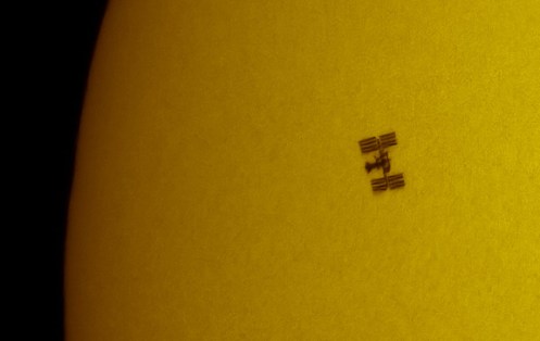 space shuttle Endeavor docked with the International Space Station crossing the face of the sun