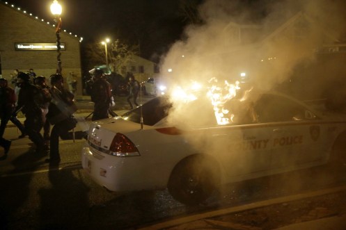 A police vehicle is vandalised and set on fire. (AP Photo-David Goldman)