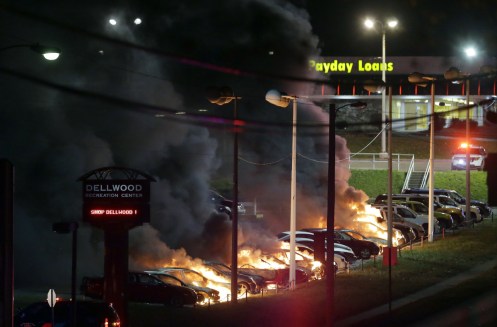 Cars burn at a dealership Tuesday, Nov. 25, 2014, in Dellwood, Mo..