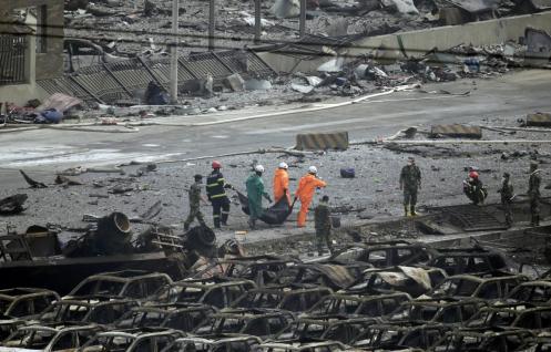 Firefighters carry the body of a victim from the site of the explosions on Friday, Aug. 14. (Jason Lee)