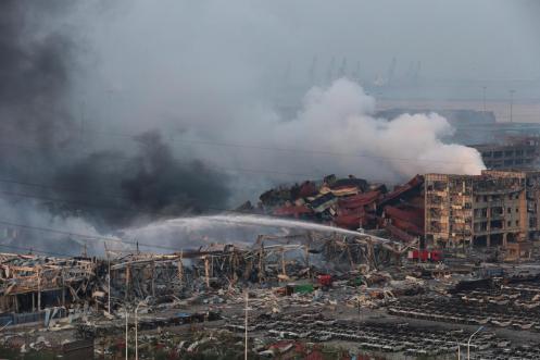 Rescuers work among hundreds of burned cars and several destroyed buildings after a huge explosion rocked the port city. China's earthquake bureau said the magnitude of the second blast was equivalent to 21 tons of TNT. (Wu Hong)